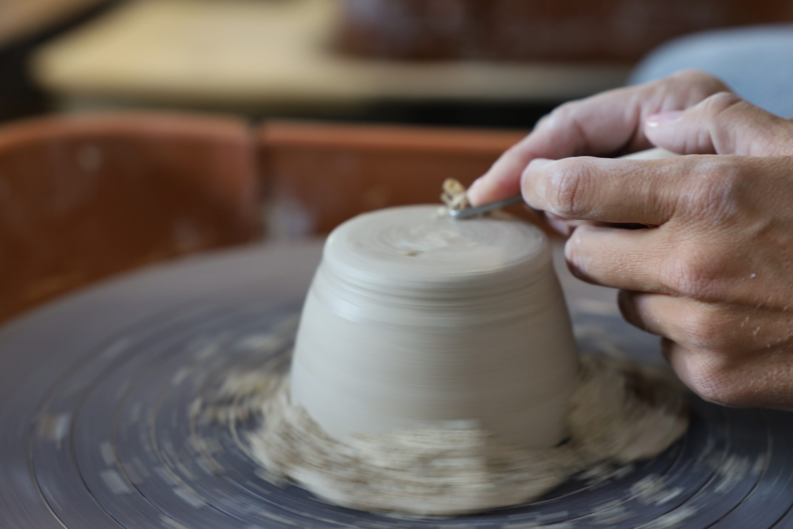Trimming the foot of a bowl on a spinning wheel